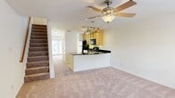 This two-story townhouse in Richmond, Virginia, offers 1,020 square feet of well-designed living space. The property features two bedrooms, including a spacious primary bedroom of 160 square feet, and three bathrooms for added convenience. The ground floor spans 530 square feet, while the upper level covers 490 square feet.

The modern kitchen is a highlight, boasting light wood cabinetry, black appliances, and a curved breakfast bar with a sleek black countertop. Track lighting adds a contemporary touch, while the open layout seamlessly connects to the living area. The bedrooms are generously sized with plush carpeting, large windows for natural light, and ceiling fans for comfort. Each room offers ample closet space.

The bathrooms are well-appointed, featuring clean lines and neutral tones. One bathroom showcases a full-sized bathtub with beige tiled walls, while another offers a pedestal sink and essential amenities. Throughout the home, white walls create a bright, airy atmosphere, complemented by the warmth of the carpeted floors in the main living areas and bedrooms.

Additional features include a staircase connecting the two floors, two hallways for easy navigation, and a dedicated closet for storage. The property's layout, with its combined kitchen and living room, promotes an open-concept feel ideal for modern living and entertaining.