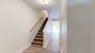 Located at 2 Pierce Dr in Rochester, NH, this two-story home offers four bedrooms and four bathrooms thoughtfully distributed across two floors. The main level provides an open, welcoming layout with light wood-tone flooring throughout the common areas. The kitchen stands out with rich dark wood cabinetry, granite countertops, and stainless steel appliances including a range, microwave, and refrigerator. The main living area features recessed lighting, sliding glass door access to the outdoors, and ample natural light through multiple windows. A carpeted staircase with a warm wood handrail connects the two floors, complemented by clean white walls that create a bright, cohesive aesthetic. The upper level houses the spacious primary bedroom, which includes multiple closets with built-in storage, along with additional well-sized bedrooms, each fitted with carpet flooring and windows that bring in natural light. The bathrooms are finished with wood-tone LVP flooring, granite-topped vanities, and paneled white doors with chrome hardware. Three additional closets throughout the home provide generous storage. The neutral color palette, clean lines, and consistent finishes across both floors give the entire home a polished, move-in-ready feel.
