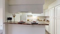 Located at 580 Pear Orchard Rd in Ridgeland, Mississippi, this single-floor residence offers a practical and comfortable layout throughout. The kitchen is equipped with white cabinetry, granite-style countertops, a full suite of white appliances including a refrigerator and range, and a pass-through breakfast bar that connects to the adjacent living area. The living room is carpeted and features a ceiling fan, a tile-surround fireplace, and a sliding glass door that opens to a private outdoor balcony, allowing natural light to fill the space. Multiple bedrooms are carpeted and include natural light from windows with outdoor views of surrounding greenery. The primary bedroom features two closets and a ceiling fan, while a secondary bedroom offers its own window and ample space. Two bathrooms serve the residence — the full bath includes a tub/shower combination, wood-look flooring, a large vanity mirror, and granite-style countertops with white cabinetry. The second bathroom mirrors this aesthetic with a wide vanity countertop, a large mirror, and wood-look flooring. Textured ceilings are consistent throughout the home, contributing to its classic character. The overall layout is efficient and well-connected, making this a functional and inviting single-floor home.