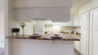 Located at 580 Pear Orchard Rd in Ridgeland, Mississippi, this single-floor residence offers a practical and comfortable layout throughout. The kitchen is equipped with white cabinetry, granite-style countertops, a full suite of white appliances including a refrigerator and range, and a pass-through breakfast bar that connects to the adjacent living area. The living room is carpeted and features a ceiling fan, a tile-surround fireplace, and a sliding glass door that opens to a private outdoor balcony, allowing natural light to fill the space. Multiple bedrooms are carpeted and include natural light from windows with outdoor views of surrounding greenery. The primary bedroom features two closets and a ceiling fan, while a secondary bedroom offers its own window and ample space. Two bathrooms serve the residence — the full bath includes a tub/shower combination, wood-look flooring, a large vanity mirror, and granite-style countertops with white cabinetry. The second bathroom mirrors this aesthetic with a wide vanity countertop, a large mirror, and wood-look flooring. Textured ceilings are consistent throughout the home, contributing to its classic character. The overall layout is efficient and well-connected, making this a functional and inviting single-floor home.