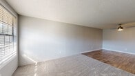 Located at 3291 S. Sanford Ave in Sanford, Florida, this 2-bedroom, 1-bathroom single-story unit offers a straightforward and functional layout designed for comfortable everyday living. The living room serves as the heart of the home, featuring soft carpet flooring, neutral gray walls, and a textured ceiling that adds character. Natural light filters in through a front-facing window, creating a bright and welcoming atmosphere. Wood-look flooring transitions seamlessly from the entryway into the kitchen and hallways, providing a cohesive aesthetic throughout the common areas. The kitchen is well-appointed with crisp white shaker-style cabinetry, granite-look countertops, a stainless steel double-basin sink, and a white electric range, offering ample storage and prep space. Both bedrooms are carpeted and finished with the same neutral tones, providing a calm and restful environment. The primary bedroom includes a sliding-door closet with built-in shelving for organized storage. The full bathroom is clean and efficiently laid out, featuring a combined tub and shower unit, a white vanity with storage, and wood-look flooring. Hallways connect the spaces smoothly, completing this tidy and well-maintained single-floor home.