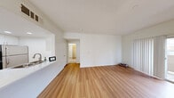 Located at 9550 W Sahara Ave in Las Vegas, this well-appointed 1-bedroom, 2-bathroom residence offers a thoughtfully designed single-floor layout. The open living area is anchored by warm wood-style flooring and a tile-surround fireplace, creating an inviting focal point for the main living space. Large windows allow natural light to fill the room, complementing the clean white walls throughout.

The kitchen is a functional highlight, featuring white shaker cabinetry extending to the ceiling, stainless steel appliances including a gas range, microwave, and refrigerator, and a white quartz peninsula with an integrated sink. A dedicated in-unit laundry area with a full-size washer and dryer is conveniently situated adjacent to the kitchen.

The bedroom is carpeted for comfort and is equipped with a ceiling fan and a window with blinds, providing both ventilation and natural light. The primary bathroom offers a vanity with white cabinetry, a large mirror, and a soaking tub, while a second bathroom provides additional convenience. A hallway and closet complete the layout, offering practical storage solutions. The overall aesthetic is clean, bright, and move-in ready.