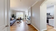 This contemporary 1-bedroom apartment at Ridge At Blue Hills offers 840 square feet of thoughtfully designed living space. The open-concept floor plan creates a seamless flow between the living, dining, and kitchen areas, ideal for both relaxation and entertaining. The primary bedroom, measuring 150 square feet, provides a generous retreat with large windows allowing plenty of natural light.

The living room features hardwood flooring, a comfortable seating area, and built-in shelving for decorative accents. The adjacent dining area comfortably accommodates a table for four, perfect for casual meals or work-from-home needs. The modern kitchen boasts white cabinetry, stainless steel appliances, and ample counter space for meal preparation.

The bathroom showcases a sleek design with a large vanity, modern fixtures, and a combination shower/tub. A spacious walk-in closet offers abundant storage space. Throughout the apartment, neutral tones and large windows create a bright, airy atmosphere. Additional features include a ceiling fan in the bedroom and crown molding in main living areas, adding subtle elegance to the space.
