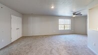Located at 1810 Graybrook Ln in New Albany, Indiana, this single-floor unit offers a efficient, well-organized layout across a compact footprint. The galley-style kitchen is outfitted with white cabinetry, warm butcher block countertops, wood-look vinyl plank flooring, and black appliances including a refrigerator, electric range, and dishwasher, providing ample counter and storage space along both walls.

A hallway connects the main areas of the unit, finished with wood-look vinyl plank flooring and lined with white panel doors leading to the closet and bathrooms. The two bathrooms each feature wood-look vinyl flooring, neutral gray walls, a vanity with butcher block countertop, and a tub-shower combination, maintaining a consistent design aesthetic throughout.

The living area is finished with wall-to-wall carpet and includes a ceiling fan with light fixture. A multi-pane window allows natural light to fill the space, contributing to an open and airy feel. Neutral wall tones and textured ceilings are consistent throughout the unit, creating a cohesive and functional interior well-suited for comfortable everyday living.