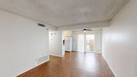 Located at 2703 Windswept Cove in Austin, TX 78745, this single-story, one-bedroom, one-bathroom home offers a practical and comfortable layout. Warm hardwood-style flooring runs throughout the living spaces, creating a cohesive and inviting atmosphere. The open-plan kitchen and living room form the heart of the home, providing a functional shared space for everyday living. The kitchen features white cabinetry, a dark countertop with an undermount sink, and a full-size refrigerator, all arranged in a clean galley-style configuration. The living room is generously proportioned, bathed in natural light through a large sliding glass door fitted with vertical blinds that opens to a private outdoor area. A ceiling fan overhead enhances comfort. The bedroom is a comfortable size, with its own ceiling fan, neutral white walls, and access to a dedicated closet for storage. The full bathroom is finished with white tilework and includes a combination shower and bathtub with chrome fixtures. Throughout the home, textured ceilings, white walls, and warm flooring tones create a clean, neutral palette ready for personalization. This well-laid-out home offers a straightforward and functional living experience in a convenient Austin location.