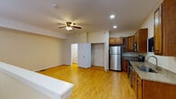 Located at 2240 Rivermont Ave in Lynchburg, Virginia, this two-floor residence offers a well-appointed and functional layout with warm, consistent finishes throughout. The main level features gleaming hardwood floors that extend across the open living and kitchen areas, creating a cohesive and inviting atmosphere. A staircase connects the two floors, adding a sense of vertical dimension to the space.

The kitchen is a standout feature, showcasing rich wood cabinetry, granite countertops, and a full suite of stainless steel appliances including a refrigerator, electric range, built-in microwave, and dishwasher. Recessed lighting and a ceiling fan enhance both function and comfort in the main living area, which also includes a closet for convenient storage.

The bedroom is generously sized and features hardwood flooring, a ceiling fan with light fixture, and a large double-door closet providing ample storage. The bathroom on this level includes a full tub-shower combination with chrome fixtures in a clean, bright setting. A second bathroom features a stylish dark-wood vanity with a white basin sink, framed mirror, and elegant overhead lighting, adding a modern touch. Throughout the space, neutral wall tones and warm wood elements create a cohesive and comfortable living environment.