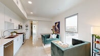 Located on Venice Boulevard in the heart of Los Angeles, this thoughtfully designed one-bedroom, one-bathroom unit offers a clean, modern aesthetic throughout. Polished concrete floors span the entire space, lending an industrial-chic character that complements the crisp white walls and contemporary finishes.

The open-concept kitchen and living area serves as the heart of the unit. The kitchen is outfitted with sleek white flat-front cabinetry, quartz countertops, stainless steel appliances including a gas range, built-in microwave, and dishwasher — providing a fully functional and stylish cooking space. The living area flows seamlessly from the kitchen, bathed in natural light from large floor-to-ceiling windows that frame views of the surrounding Los Angeles streetscape.

The bedroom is a comfortable, well-proportioned retreat featuring its own large window that fills the room with natural light and offers additional city views. A dedicated closet provides practical storage. The bathroom maintains the unit's clean, minimal design with white subway tile, a soaking tub with overhead shower, and a tall storage cabinet. An in-unit laundry area and hallway complete the thoughtful layout, making this a highly functional and stylish urban residence.