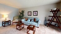 Located at 1346 Carriage Hill Ln in Hamilton, Ohio, this single-floor residence offers a well-organized layout designed for comfortable everyday living. The living room is a welcoming space with soft carpeting, neutral-toned walls, and a textured ceiling that adds subtle character. It provides ample room for seating and relaxation.

The kitchen is outfitted with rich dark cabinetry, granite countertops, black appliances including a range, microwave, and refrigerator, and light hardwood-style flooring. Its galley configuration maximizes efficiency while offering generous counter and storage space.

Adjacent to the kitchen, the dining area is bathed in natural light from a large sliding glass door with vertical blinds that open to a view of the lush outdoor greenery. Track lighting overhead and warm wood flooring complete this inviting space.

The home includes two bedrooms, each with plush carpeting, neutral walls, and ample closet space. Bifold closet doors and textured ceilings are consistent throughout. One bedroom features a window that allows natural light to fill the room.

The bathroom is cleanly appointed with dark wood cabinetry, a granite-topped vanity, wood-style flooring, and a full tub and shower combination. The overall ambiance of this home is calm, practical, and move-in ready.