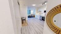 Located on the 7th floor at 529 3rd Avenue SW in the heart of Calgary's downtown, this thoughtfully designed two-bedroom unit offers a bright, open-concept layout finished with light hardwood-style flooring and crisp white walls throughout. The galley-style kitchen is a standout feature, showcasing sleek white cabinetry with matte black hardware, a marble-effect backsplash, quartz countertops, and a full suite of stainless steel appliances including a French door refrigerator, electric range, built-in microwave, and dishwasher. The kitchen flows seamlessly into the living and dining area, which benefits from natural light streaming through large windows framing views of the surrounding downtown skyline. The living room provides a comfortable retreat with ample space for seating and entertaining. The primary bedroom is a well-proportioned private space featuring light flooring and clean, neutral walls. The second bedroom is cozy and equally well-appointed, with warm lighting and a contemporary feel. A small dining nook near the entrance adds functional versatility to the layout. The unit's modern, minimalist aesthetic, combined with its central Calgary location, makes it a practical and stylish urban residence.