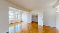 Located at 3200 16th St NW, Unit 505 in Washington, DC, this studio unit offers a well-organized single-floor layout that includes a living room, dining area, kitchen, bathroom, and two closets. The living and dining areas are unified by gleaming parquet hardwood flooring, which lends warmth and classic character throughout. Wall-mounted sconce lighting flanks the entry wall, adding a refined touch to the bright, neutral interior. A ceiling fan in the main living area contributes to comfort, while windows allow natural light to fill the space. The kitchen features white cabinetry with raised-panel doors, granite-toned countertops, a white subway tile backsplash, and white appliances including a range, microwave, and refrigerator. Light tile flooring and a window keep the kitchen feeling fresh and functional. The bathroom continues the classic aesthetic with white subway tile walls accented by navy border tiles, a soaking tub with shower, and a window for natural ventilation. Storage is well-addressed with two closets — one generously sized walk-in closet equipped with built-in shelving and hanging rods, finished with the same parquet flooring found throughout the main living areas.