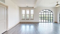 This well-appointed two-story residence in Lewisville, TX offers four bedrooms and three bathrooms across a generously sized layout. The main floor provides the majority of the living space, while the upper level adds additional room and privacy. Warm hardwood-style flooring flows through the main living areas and kitchen, which is equipped with stainless steel appliances, gray shaker cabinetry, a subway tile backsplash, and ample counter space. The open kitchen connects seamlessly to the living area for easy entertaining. Bedrooms are carpeted for comfort, with ceiling fans in each room. The expansive primary bedroom is a standout, featuring dramatic floor-to-ceiling arched windows that flood the space with natural light and offer tree-lined views. A walk-in closet with wire shelving provides generous storage. Secondary bedrooms are well-sized, each with closet access. The bathrooms range from a sleek glass-enclosed shower with large-format tile in the primary bath to a full tub-shower combo with tile surround in the secondary bath. A covered outdoor patio with a ceiling fan rounds out the space, offering a comfortable extension for outdoor living. Two staircases connect the floors for added convenience.