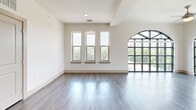 This well-appointed two-story residence in Lewisville, TX offers four bedrooms and three bathrooms across a generously sized layout. The main floor provides the majority of the living space, while the upper level adds additional room and privacy. Warm hardwood-style flooring flows through the main living areas and kitchen, which is equipped with stainless steel appliances, gray shaker cabinetry, a subway tile backsplash, and ample counter space. The open kitchen connects seamlessly to the living area for easy entertaining. Bedrooms are carpeted for comfort, with ceiling fans in each room. The expansive primary bedroom is a standout, featuring dramatic floor-to-ceiling arched windows that flood the space with natural light and offer tree-lined views. A walk-in closet with wire shelving provides generous storage. Secondary bedrooms are well-sized, each with closet access. The bathrooms range from a sleek glass-enclosed shower with large-format tile in the primary bath to a full tub-shower combo with tile surround in the secondary bath. A covered outdoor patio with a ceiling fan rounds out the space, offering a comfortable extension for outdoor living. Two staircases connect the floors for added convenience.