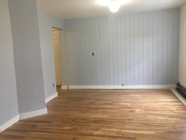 Living room view from bottom of stairs (looking at entrance) with recently finished red birch flooring. Spacious! - 12 Boynton Street