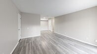 Located at 2708 Fox Harbour Dr in Indianapolis, Indiana, this single-floor residence presents a clean, move-in-ready interior defined by consistent neutral tones and updated finishes throughout. The layout, as seen in the floor plan, offers a well-organized arrangement of living spaces, bedrooms, and service areas that flow logically from one to the next.

The main living area is notably open and spacious, featuring light gray wood-look plank flooring that extends throughout the home, crisp white baseboards, and warm greige walls that create a neutral, versatile backdrop. A sliding glass door allows natural light to fill the room while providing outdoor access. A secondary open room mirrors this aesthetic, offering flexible use as a den, office, or additional living space.

The bedrooms are comfortably sized, each featuring the same plank flooring, natural light from windows with blinds, and textured ceilings. The kitchen is equipped with white cabinetry featuring brushed nickel hardware, white countertops, and black appliances including an electric range with overhead ventilation. The bathroom includes a white vanity with an integrated sink, a framed mirror, and a full tub-shower surround with brushed nickel fixtures, maintaining the home's clean, cohesive aesthetic.