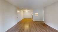 Located at 7700 Gleason Dr in Knoxville, TN, this 2-bedroom, 2-bathroom residence offers a well-organized, single-floor layout designed for comfortable everyday living. The combined dining and living area is bright and open, featuring wood-look flooring, a ceiling fan, and sliding glass doors that lead to a private balcony, filling the space with natural light. A pass-through window connects the living area to the kitchen, enhancing the sense of openness. The galley-style kitchen is appointed with white shaker cabinetry, granite-style countertops, a subway tile backsplash, a stainless steel sink, and black appliances, including a full-size refrigerator. A pantry and an adjacent utility room with a water heater provide added storage and functionality. The dedicated laundry room includes washer hookups and a shelving unit for organization. Both bedrooms are carpeted and well-lit by large windows, with the primary bedroom offering a generously sized footprint and its own bathroom. The bathrooms feature white vanities with granite-style countertops and clean tiled tub-shower combinations. Three closets throughout the unit offer ample storage. The neutral color palette and textured ceilings complete the cohesive, move-in-ready aesthetic of this Knoxville residence.
