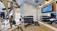 Located at 1038 Bayridge Dr in Lewis Center, Ohio, this fitness center offers a well-appointed workout facility designed to support a comprehensive exercise routine. The space is organized across a single floor and features high ceilings that contribute to an open, airy atmosphere, complemented by light-toned walls painted in a soft blue-gray palette that creates a clean and motivating environment. Recessed lighting and wall-mounted sconces provide ample illumination throughout.

The main workout area is equipped with a multi-station cable machine for strength and resistance training, a three-tier dumbbell rack stocked with a wide range of free weights, kettlebells, and an adjustable workout bench — offering users the tools needed for both targeted and full-body training. A large framed mirror along one wall enhances the sense of space while allowing users to monitor their form. A wall-mounted flat-screen TV adds an entertainment element to workouts.

The facility includes a dedicated entry area with a water fountain and access to natural light through a glass-paneled door, providing a welcoming transition into the space. Neutral, textured flooring ties the room together, balancing functionality with a polished aesthetic. Overall, this fitness center provides a practical, well-maintained environment suited for a variety of fitness goals.