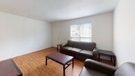 This multi-floor residence in Harrisonburg, Virginia offers a practical and comfortable layout spread across three floors. The living room serves as the central gathering space, featuring warm hardwood-style flooring, neutral white walls, and windows that allow natural light to filter in, creating an open and inviting atmosphere. The kitchen is well-appointed with honey-toned wood cabinetry, dark granite-style countertops, and black appliances including an electric range, built-in microwave, and dishwasher, all complemented by matching hardwood-style flooring. Multiple bedrooms are carpeted for comfort and each includes a ceiling fan, window with blinds providing natural light and outdoor views, and sufficient space for furnishings. The bathrooms are clean and functional, each featuring a tub-shower combination, toilet, and vanity with wood cabinetry and light fixtures above the mirror. Tile flooring runs throughout the bathrooms, adding a durable, easy-to-maintain finish. The overall design of the space is straightforward and practical, with a neutral color palette of whites and beiges that lends itself to easy personalization. The residence is well-suited for those seeking a no-frills, functional home in Harrisonburg, VA.