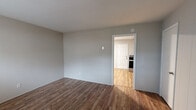 This two-story, 2-bedroom, 1-bathroom home is thoughtfully laid out across two equally sized floors, offering a practical and efficient use of space. The interior features a consistent neutral color palette with light gray walls and wood-look flooring that flows throughout, giving the home a cohesive and clean aesthetic.

The main floor includes a living room with a front entry door, large windows that bring in natural light, and baseboard heating. The kitchen is a standout feature, equipped with white shaker-style cabinetry, granite countertops, a subway tile backsplash, a stainless steel refrigerator, and a stainless steel range — all combining to create a functional and attractive cooking space. A separate door in the kitchen provides additional access.

Upstairs, the two bedrooms offer comfortable proportions, with the primary bedroom providing a generous amount of space. The rooms maintain the same neutral tones and wood-look flooring found throughout the home. The full bathroom features a tiled tub-and-shower combination, a window for natural ventilation, a toilet, and a vanity with a white cabinet. A staircase connects the two floors, completing the home's straightforward and practical layout.