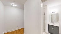 This thoughtfully designed one-bedroom, one-bathroom unit at 300 E Main St in Bound Brook, NJ offers a clean, modern aesthetic throughout. Light wood-tone flooring flows seamlessly across the entire space, creating a warm and cohesive look. The open-concept kitchen and living area is anchored by a well-appointed kitchen featuring slate-blue cabinetry, a white subway tile backsplash, stainless steel appliances including a range, dishwasher, microwave, and refrigerator, and a window overlooking the surrounding streetscape. A wall-mounted mini-split system provides efficient climate control in multiple rooms. The living area opens into a striking curved alcove enclosed by floor-to-ceiling windows with dark framing, offering sweeping views of downtown Bound Brook and the hills beyond — a standout architectural feature of the unit. The bedroom is a comfortable, well-lit space with a large window, a wall-mounted mini-split unit, and a private door. The bathroom is finished with large-format light stone-look tile and features a frameless glass walk-in shower with chrome fixtures and a hand-held showerhead. The unit presents a fresh, contemporary finish palette throughout, ideal for those seeking modern urban living.