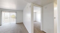 Located at 1220 Tree Line Dr in Las Vegas, NV, this two-bedroom, one-bathroom unit offers a clean, functional layout across a single floor. The interior is finished with a neutral white color palette throughout, creating a bright and airy atmosphere.

The kitchen features white cabinetry, light wood-style tile flooring, and a full suite of white appliances including a gas range, microwave, and refrigerator. Adjacent to the kitchen, the spacious living area is carpeted and filled with natural light from a large sliding glass door that opens to a private outdoor patio.

Both bedrooms are carpeted and share the same clean, minimalist aesthetic, with vertical blinds on the windows that allow for natural light and outdoor views. The primary bedroom offers a comfortable footprint, while each bedroom includes closet storage — one with a sliding-door closet fitted with a hanging rod, and the other with a dedicated walk-in closet featuring wire shelving.

The full bathroom includes a shower-tub combination and light wood-style tile flooring, consistent with the kitchen. The unit's straightforward, well-maintained design makes efficient use of its space, offering comfortable living in a convenient Las Vegas location.