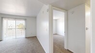 Located at 1220 Tree Line Dr in Las Vegas, NV, this two-bedroom, one-bathroom unit offers a clean, functional layout across a single floor. The interior is finished with a neutral white color palette throughout, creating a bright and airy atmosphere.

The kitchen features white cabinetry, light wood-style tile flooring, and a full suite of white appliances including a gas range, microwave, and refrigerator. Adjacent to the kitchen, the spacious living area is carpeted and filled with natural light from a large sliding glass door that opens to a private outdoor patio.

Both bedrooms are carpeted and share the same clean, minimalist aesthetic, with vertical blinds on the windows that allow for natural light and outdoor views. The primary bedroom offers a comfortable footprint, while each bedroom includes closet storage — one with a sliding-door closet fitted with a hanging rod, and the other with a dedicated walk-in closet featuring wire shelving.

The full bathroom includes a shower-tub combination and light wood-style tile flooring, consistent with the kitchen. The unit's straightforward, well-maintained design makes efficient use of its space, offering comfortable living in a convenient Las Vegas location.