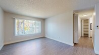 Located at 5820 Sutter Ave in Carmichael, CA, this thoughtfully designed one-bedroom, two-bathroom unit offers a comfortable and functional single-floor layout. The combined kitchen and living room area forms the heart of the space, with wood-style laminate flooring, neutral walls, and a large window fitted with vertical blinds that invite abundant natural light and offer views of the surrounding greenery. A wall-mounted HVAC unit provides climate control in the living area. The kitchen is efficiently arranged in a galley style, featuring white cabinetry with brushed nickel hardware, speckled quartz-style countertops, a stainless steel refrigerator, a dishwasher, and a gas range — all set over light wood-style flooring. The bedroom is carpeted for comfort and includes a natural light-filled window, access to a built-in closet, and an adjoining walk-in closet with open shelving for generous storage. Two bathrooms serve the unit, one of which connects directly to the bedroom area and features a speckled countertop vanity. Both closets offer practical organization solutions. Textured ceilings are consistent throughout, contributing to the unit's clean, no-fuss aesthetic. This unit provides a well-organized, move-in ready living experience in a convenient Carmichael location.