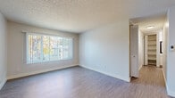 Located at 5820 Sutter Ave in Carmichael, CA, this thoughtfully designed one-bedroom, two-bathroom unit offers a comfortable and functional single-floor layout. The combined kitchen and living room area forms the heart of the space, with wood-style laminate flooring, neutral walls, and a large window fitted with vertical blinds that invite abundant natural light and offer views of the surrounding greenery. A wall-mounted HVAC unit provides climate control in the living area. The kitchen is efficiently arranged in a galley style, featuring white cabinetry with brushed nickel hardware, speckled quartz-style countertops, a stainless steel refrigerator, a dishwasher, and a gas range — all set over light wood-style flooring. The bedroom is carpeted for comfort and includes a natural light-filled window, access to a built-in closet, and an adjoining walk-in closet with open shelving for generous storage. Two bathrooms serve the unit, one of which connects directly to the bedroom area and features a speckled countertop vanity. Both closets offer practical organization solutions. Textured ceilings are consistent throughout, contributing to the unit's clean, no-fuss aesthetic. This unit provides a well-organized, move-in ready living experience in a convenient Carmichael location.