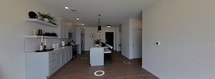 This contemporary single-story home in Bismarck, North Dakota, offers 940 square feet of thoughtfully designed living space. The property features two bedrooms, including a primary bedroom of 130 square feet, and two full bathrooms. The modern kitchen is a highlight, boasting white cabinetry, stainless steel appliances, and a subway tile backsplash. Open shelving and a central island add both style and functionality.

The living areas are characterized by their bright, airy feel, enhanced by large windows that flood the spaces with natural light. Light-colored walls and hardwood-style flooring throughout create a cohesive, modern aesthetic. The bedrooms are generously sized, with the primary bedroom featuring sliding closet doors and ample natural light.

Both bathrooms are designed with a contemporary flair, featuring sleek fixtures and clean lines. One bathroom showcases a long vanity with plenty of counter space and storage. The property also includes a hallway and a closet for additional storage options.

Large windows in the living area and bedrooms offer views of the surrounding neighborhood, connecting the interior spaces with the outdoors. The overall design emphasizes simplicity and functionality, making efficient use of the available square footage while maintaining a spacious feel. This property is ideal for those seeking a modern, low-maintenance home in a convenient Bismarck location.