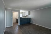 Located at 811 S Fairview St in Santa Ana, California, this single-floor unit offers a clean, contemporary living environment with thoughtful updates throughout. The open-concept layout connects the living area to the kitchen, creating an inviting and functional flow. Wood-look flooring runs throughout the space, complemented by neutral gray walls, crisp white baseboards, and crown molding that add a polished finish.

The kitchen is a standout feature, equipped with sleek blue-gray lower cabinets, high-gloss white upper cabinets, and bright white quartz countertops. A deep stainless steel farmhouse sink, stainless steel electric range, and a refrigerator complete the space, which also benefits from natural light through a window with vertical blinds.

The living areas are bright and open, each with large windows that allow natural light to filter in, a wall-mounted HVAC unit for climate control, and textured ceilings throughout. The bathroom is neatly appointed with a modern gray vanity, white countertop, large mirror, and wood-look tile flooring, maintaining the cohesive design language found throughout the unit.

Overall, this space presents a fresh, move-in-ready environment with modern upgrades in a well-located Santa Ana neighborhood.
