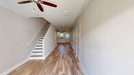 Located at 125 Promenade Place in Brunswick, Georgia, this two-story townhome features a thoughtfully designed layout spread across two floors. The exterior showcases board-and-batten siding with a metal roof, an attached garage, and a concrete driveway set within a well-maintained community.

The main floor hosts the living room, kitchen, and garage. The kitchen is outfitted with white shaker-style cabinetry, quartz countertops, subway tile backsplash, stainless steel appliances, and light hardwood flooring — all accented by crown molding and recessed lighting.

Upstairs, three bedrooms provide comfortable retreats, each featuring light hardwood floors, crown molding, ceiling fans, and recessed lighting. The generously sized primary bedroom includes dual closets and connects to a well-appointed en-suite bathroom with a white vanity, quartz countertops, and brushed nickel fixtures. The additional bathrooms mirror this refined aesthetic with matching quartz vanities, framed mirrors, and stylish lighting.

Throughout the home, neutral warm-toned walls, wide baseboards, and consistent hardwood-style flooring create a cohesive, modern ambiance. A staircase connects both floors, and a hallway provides efficient flow between rooms. The home combines functional design with quality finishes in a welcoming Brunswick community setting.