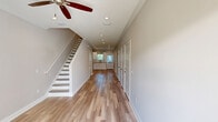 Located at 125 Promenade Place in Brunswick, Georgia, this two-story townhome features a thoughtfully designed layout spread across two floors. The exterior showcases board-and-batten siding with a metal roof, an attached garage, and a concrete driveway set within a well-maintained community.

The main floor hosts the living room, kitchen, and garage. The kitchen is outfitted with white shaker-style cabinetry, quartz countertops, subway tile backsplash, stainless steel appliances, and light hardwood flooring — all accented by crown molding and recessed lighting.

Upstairs, three bedrooms provide comfortable retreats, each featuring light hardwood floors, crown molding, ceiling fans, and recessed lighting. The generously sized primary bedroom includes dual closets and connects to a well-appointed en-suite bathroom with a white vanity, quartz countertops, and brushed nickel fixtures. The additional bathrooms mirror this refined aesthetic with matching quartz vanities, framed mirrors, and stylish lighting.

Throughout the home, neutral warm-toned walls, wide baseboards, and consistent hardwood-style flooring create a cohesive, modern ambiance. A staircase connects both floors, and a hallway provides efficient flow between rooms. The home combines functional design with quality finishes in a welcoming Brunswick community setting.