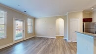 This well-appointed one-bedroom, one-bathroom unit in Murfreesboro, Tennessee offers a thoughtfully designed single-floor layout. The open-concept living and kitchen area serves as the heart of the home, featuring warm hardwood-style flooring, neutral-toned walls, and elegant crown molding throughout. A charming arched doorway adds architectural character to the living space, which is filled with natural light from multiple windows and a glass exterior door. The kitchen is a standout feature, boasting rich dark-wood cabinetry, granite countertops, a subway tile backsplash, and a full suite of stainless steel appliances including a range, microwave, refrigerator, and dishwasher. A peninsula with pendant lighting and an integrated sink provides additional prep space and casual dining potential. The bedroom offers plush carpeting, a ceiling fan, and dual windows that invite ample natural light. The bathroom mirrors the kitchen's design aesthetic with matching dark cabinetry, granite countertops, and wood-style flooring, complemented by a bright window. A dedicated closet and hallway complete this efficiently designed and move-in-ready home.