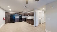 Located at 10 Frazier Rd in Greenville, SC, this single-story, three-bedroom, two-bathroom home offers a thoughtfully designed layout with modern finishes throughout. The open kitchen is a standout feature, showcasing rich dark espresso shaker-style cabinetry, light granite-look countertops, a full suite of black appliances including a refrigerator, electric range, microwave, and dishwasher, and light wood-look vinyl plank flooring. Recessed lighting and a ceiling fan keep the space bright and comfortable. The living area continues the light flooring and features a glass-panel entry door that brings in natural light. The three bedrooms are carpeted for comfort, finished with neutral gray walls, ceiling fans, and ample closet access. The primary bedroom offers a generous footprint with direct access to adjoining spaces. The two bathrooms are clean and functional, featuring wood-toned vanity cabinetry, white countertops, and a tub-shower combination with tile surround. A dedicated laundry room houses a full-size GE washer and dryer with wire shelving above for added storage. The home's cohesive design, practical room count, and in-unit amenities make it a well-rounded residence in the Greenville area.
