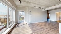 Located at 952 W Carmen Ave in Chicago's vibrant Uptown neighborhood, this 2-bedroom, 2-bathroom loft-style residence blends industrial character with modern finishes throughout. Exposed concrete ceilings and wood-look flooring run throughout the space, creating a contemporary urban aesthetic. The open living area is bathed in natural light from large windows and a glass door that opens to a private balcony overlooking the Chicago skyline. Track lighting mounted on the concrete ceiling adds both ambiance and function. The kitchen is well-appointed with white shaker cabinetry, dark granite countertops, a white subway tile backsplash, a center island, and a full suite of stainless steel appliances. A long hallway with the same warm flooring connects the living spaces to the private quarters. Both bedrooms feature exposed concrete ceilings, ample closet space with paneled double doors, and windows offering city views. The bathrooms are finished with marble-style tile, including large-format wall tile surrounding a soaking tub and shower, polished tile flooring, white vanity cabinetry, a dark countertop, and a well-lit mirror. This thoughtfully designed space balances raw industrial details with clean, modern touches throughout.