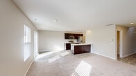 Located at 1351 Verdigris Pass in Huntertown, Indiana, this two-story home offers a well-organized layout across two floors. The main level features an open-concept kitchen and living area filled with natural light from large windows and a sliding door. The kitchen is appointed with rich dark cabinetry, stainless steel appliances, a center island with a light-toned countertop and built-in sink, and recessed lighting overhead. Light wood-style flooring flows throughout the main level, transitioning to plush carpet in the living area. The attached garage provides convenient access and additional utility space. Upstairs, the upper level is reached via a carpeted staircase with a clean white railing and opens to a hallway with light wood flooring. Three bedrooms are situated on this floor, including a generously sized primary bedroom. The bedrooms feature neutral tones, soft carpet, and ample closet space — with seven closets total throughout the home. Three full bathrooms serve the home, including one featuring a soaking tub and shower combination with brushed nickel fixtures. The overall aesthetic is clean and contemporary, with neutral walls, recessed lighting, and consistent finishes that create a bright and move-in-ready atmosphere.