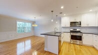 Located at 2-48 Grove Ave in Cedar Grove, NJ, this thoughtfully designed two-bedroom, two-bathroom residence offers a refined living experience across a single floor. The open-concept living, dining, and kitchen area serves as the heart of the home, showcasing warm hardwood flooring and elegant wainscoting that lends a classic, polished character throughout. Crown molding adds a finishing touch to each room.

The kitchen is a standout feature, equipped with crisp white shaker cabinetry, dark granite countertops, stainless steel appliances, a subway tile backsplash, and a central island with pendant lighting — ideal for both cooking and casual entertaining. The adjacent dining area benefits from generous natural light through large windows and is highlighted by a stylish drum pendant light.

The living room continues the refined aesthetic with wainscoting, hardwood floors, and a sliding glass door that invites in additional natural light. Both bedrooms offer plush carpeting and ample natural light, with the primary bedroom providing a generous amount of space. The bathrooms are elegantly finished, with one featuring marble-look tile flooring, a dark wood vanity with a stone countertop, and a glass-enclosed walk-in shower.