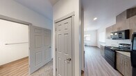 Located at 2252 NE Colleen St in Prineville, Oregon, this single-floor home offers a well-designed layout with a clean, contemporary aesthetic throughout. The main living area transitions seamlessly from carpet to wood-look flooring, creating a clear distinction between relaxation and functional spaces. A pendant chandelier illuminates the dining area, which benefits from natural light through large windows and opens directly to the kitchen. The kitchen is equipped with warm wood-tone cabinetry, granite-style countertops, black appliances including a range and refrigerator, and a built-in microwave — all set against durable wood-look flooring. Hallways connect the living spaces to the bedrooms and bathrooms via classic six-panel doors. The primary bedroom features vaulted ceilings that lend an airy, open feel, plush carpeting, and an adjacent vanity with granite-style counters. A second bedroom offers generous proportions, carpeted floors, and a built-in closet. Two bathrooms serve the home: one with a soaking tub and shower combination, and another with a dedicated walk-in shower stall — both finished with wood-look tile flooring, granite-style vanity tops, and brushed nickel fixtures. The overall design is neutral and move-in ready, combining practical finishes with a comfortable, modern sensibility.