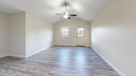 Located at 890 Tallmadge Rd in Kent, Ohio, this single-floor, 2-bedroom, 2-bathroom home delivers a functional and modern living experience. The open kitchen is a standout feature, boasting rich dark-stained wood cabinetry, granite countertops, a subway tile backsplash, and a full suite of stainless steel appliances including a range, microwave, dishwasher, and refrigerator, all set atop durable light wood-look flooring. The living room impresses with vaulted ceilings, a ceiling fan, light wood-look flooring, and natural light streaming in through multiple windows and a glass-panel entry door. Both bedrooms are finished with plush carpeting and ceiling fans; the primary bedroom offers a spacious layout with a double-door closet, while the second bedroom also features a large window with outdoor views and ample natural light. Each bathroom is appointed with granite-topped vanities, dark wood cabinetry, brushed nickel fixtures, and large mirrors. A dedicated utility room adds practical convenience to the layout. Neutral wall tones and consistent finishes throughout create a cohesive and welcoming ambiance across the entire home.