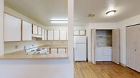 Located at 2727 E 53rd Ave in Spokane, WA, this one-bedroom, one-bathroom unit offers a practical and efficient single-floor layout. The combined kitchen and living area forms the heart of the home, with the kitchen featuring light wood-trimmed cabinetry, ample upper and lower storage, a full suite of white appliances including a range and refrigerator, and a peninsula counter that separates the kitchen from the living space. Wood-style laminate flooring runs throughout the kitchen and common areas, adding warmth and easy maintenance. A dedicated laundry closet conveniently houses a full-size washer and dryer just off the kitchen. The living room provides a comfortable, open area with a window that brings in natural light and views of surrounding greenery, complemented by baseboard heating and a wall-mounted air conditioning unit. The bedroom is a well-sized, carpeted room with its own window overlooking outdoor foliage, offering a quiet and bright retreat. The bathroom includes a single-sink vanity with cabinet storage, a wall mirror with overhead lighting, and a full soaking tub with shower, all set on wood-style flooring. A dedicated closet provides additional storage to complete this well-organized unit.