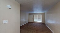 This single-floor residential unit offers a straightforward, functional layout designed for comfortable everyday living. The main living area is spacious and open, featuring dark wall-to-wall carpeting, neutral beige walls, and a textured ceiling. A large window fitted with horizontal blinds allows ample natural light to fill the room, while a front entry door provides direct access. The space transitions into additional rooms, with the flooring shifting to warm hardwood tones in key areas.

The bedrooms are well-proportioned and carpeted, each equipped with a ceiling fan for added comfort. Windows with blinds bring in natural light, and at least one bedroom includes a double-door closet offering generous storage. The neutral color palette throughout creates a calm, cohesive atmosphere.

The bathrooms are clean and functional, each featuring a full tub and shower combination with white surround panels, chrome fixtures, and a toilet. One bathroom includes a vanity with a white countertop and a window for natural ventilation, while both bathrooms feature hardwood-style flooring that contrasts neatly with the warm wall tones.

Overall, this unit presents a practical and livable floor plan with consistent finishes, ample natural light, and a neutral aesthetic that serves as a versatile canvas for personalization.