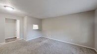 Located at 2730 Lafferty Road in Pasadena, Texas, this one-bedroom, two-bathroom unit offers a practical and well-appointed single-floor layout. The living room is a comfortable, carpeted space with neutral gray tones, white trim, and windows fitted with blinds that allow natural light to filter in. A front entry door opens directly into this welcoming area, which connects seamlessly to the rest of the unit. The kitchen features a galley-style layout with white cabinetry, granite-look countertops, wood-look flooring, and a white electric range with overhead ventilation, providing a clean and functional cooking environment. The bedroom is a well-proportioned, carpeted room with neutral walls and a window offering an outdoor view, creating a calm and restful retreat. A dedicated closet adds practical storage. Both bathrooms are finished consistently with white cabinetry, granite-look countertops, wood-look flooring, and bright lighting. One bathroom includes a full tub-shower combination with a white surround. A hallway connects the private areas of the unit, contributing to an efficient and organized flow throughout the space. The overall design is characterized by a cohesive neutral palette, consistent finishes, and a clean, functional aesthetic.