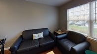 Located at Jefferson Commons in Kalamazoo, Michigan, this single-floor unit offers a practical and comfortable layout designed for everyday living. The open floor plan, visible in the dollhouse view, connects the main living areas in a straightforward, easy-to-navigate arrangement.

The kitchen is well-equipped with light wood cabinetry, dark speckled countertops, and white appliances including a coil-burner electric range with an over-the-range microwave. Ample upper and lower cabinet storage ensures plenty of room for essentials, and a dishwasher is included for added convenience.

The living area features warm hardwood-style flooring and is brightened by large windows fitted with blinds, allowing natural light to fill the space and providing views of the surrounding green outdoor areas. A ceiling fan overhead adds comfort to the room.

The bedroom is carpeted for warmth and comfort, featuring a ceiling fan with integrated lighting, a window with natural light, and a mirrored sliding closet door that adds a sense of openness. The room comfortably accommodates a bed, desk, and additional storage furniture.

Overall, the unit presents a clean, neutral palette with warm tones throughout, making it a functional and welcoming living space in the Jefferson Commons community.