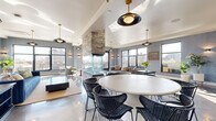 Located at 618 N Third St in Minneapolis's vibrant North Loop neighborhood, this generously sized, single-floor space blends modern sophistication with industrial character. The open-concept main living area features highly polished concrete floors that reflect abundant natural light streaming in through oversized black-framed windows, offering sweeping views of the surrounding cityscape. A striking floor-to-ceiling stacked stone fireplace serves as the architectural centerpiece, anchoring the space and dividing the lounge and dining zones. Stylish pendant lighting with brass and matte black finishes adds warmth and visual interest throughout.

A sleek wet bar with teal hexagonal tile backsplash, white cabinetry, and stainless steel appliances provides a refined entertainment focal point. The dining area accommodates a large round table with woven black chairs, while the lounge area is furnished with plush blue velvet seating. Textured herringbone wallcovering lines the hallway, which leads to an expansive rooftop terrace featuring multiple seating areas, gas grills, planters, and panoramic views of the Minneapolis skyline.

A lower-level area showcases raw exposed brick walls, concrete ceilings with visible ductwork, and dark hardwood floors — ideal for a more intimate, industrial-style gathering space complete with a ping-pong table and bar-height seating.