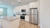 Located in Palmetto, FL, this well-appointed 2-bedroom, 2-bathroom residence offers a clean, modern aesthetic throughout its thoughtfully designed single-floor layout. Light wood-style flooring flows continuously across all rooms, creating a cohesive and bright atmosphere.

The kitchen serves as a central hub of the home, featuring white shaker cabinetry, granite countertops, a center island with seating, recessed lighting, and a full suite of stainless steel appliances including a refrigerator, range, microwave, and dishwasher.

Both bedrooms are bright and airy, benefiting from large windows with exterior views and ceiling fans. The spacious primary bedroom connects to a well-sized en-suite bathroom with a granite-topped vanity featuring white cabinetry, a tub-shower combination with white subway tile surround, and warm wood flooring. A walk-in closet with wire shelving provides generous storage. The second bathroom mirrors the same design language, offering a granite vanity, white cabinetry, and a tub-shower with subway tile.

Each bedroom is paired with its own dedicated walk-in closet fitted with wire shelving systems, maximizing organizational flexibility. The overall palette of soft neutrals, white trim, and natural wood tones lends the space a clean, contemporary feel throughout.