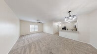 Located at 6332 Clock Tower Dr in Walbridge, Ohio, this single-floor home offers five bedrooms and three bathrooms within a thoughtfully designed layout. The open-concept living and dining area serves as the heart of the home, featuring plush neutral carpeting, a ceiling fan, and natural light streaming through a large window. A stylish pendant light fixture marks the transition into the kitchen, which is equipped with crisp white cabinetry, granite-look countertops, stainless steel appliances including a dishwasher and microwave, and a deep black undermount sink with modern faucet. Light wood-look flooring in the kitchen adds a clean contrast to the carpeted living spaces. The five bedrooms are bright and well-proportioned, each featuring plush carpeting, ceiling fans, and windows that bring in ample natural light. The primary bedroom offers generous space with its own closet. Three full bathrooms are finished with marble-look countertops and clean white fixtures. A dedicated laundry room houses a full-size washer and dryer. Four closets throughout the home provide excellent storage. The overall aesthetic is fresh and modern, with a neutral palette that creates a bright, welcoming atmosphere throughout.