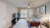 Located at 5639 Old Chapel Hill Rd in Chapel Hill, NC, this single-floor residence offers a thoughtfully designed layout with comfortable living spaces throughout. The living room serves as the heart of the home, featuring wood-look flooring, a ceiling fan with light fixture, and French doors fitted with plantation shutters that invite natural light and provide outdoor access. The seating area is well-proportioned, offering a relaxed yet functional atmosphere. Adjacent to the living room is a dedicated dining area with neutral wall tones, providing an intimate setting for meals. The galley-style kitchen is efficiently designed with white upper cabinetry, gray lower cabinets, light stone-look countertops, a stainless steel sink, and black appliances including a refrigerator and electric range. Wood-look flooring carries through the kitchen for a cohesive aesthetic. The residence includes two carpeted bedrooms, each equipped with a ceiling fan, window with blinds for natural light, and easy access to closet storage. The bathroom features a marble-look vanity countertop, a tub-shower combination, and clean, neutral finishes throughout. Soft, neutral tones unify the entire space, creating a calm and welcoming ambiance.