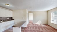 Located at 320 E West Pkwy in Anderson, SC, this single-floor, one-bedroom, one-bathroom unit offers a well-organized and functional layout. The kitchen is equipped with white cabinetry, a gas range, dishwasher, and refrigerator, complemented by dark granite-style countertops, a tile backsplash, and durable hardwood-style flooring. A pantry provides additional storage, and a breakfast bar with a dark countertop separates the kitchen from the living area. The living room features neutral-toned carpet and a textured ceiling, creating a warm, comfortable atmosphere. Natural light filters in through the windows, brightening the space throughout the day. The spacious primary bedroom is carpeted and includes a ceiling fan with a light fixture and a window with blinds that allows ample natural light. Two closets offer generous storage throughout the unit. The bathroom includes a full tub-shower combination with white tile surround and chrome fixtures. The overall design is straightforward and practical, with a neutral color palette of warm beige tones that provides a clean, move-in-ready canvas throughout the home.