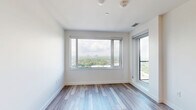 Located at 50 High Park Ave in Toronto's vibrant High Park neighbourhood, this one-bedroom, one-bathroom unit offers a thoughtfully designed layout across a single floor. Light wood-style flooring flows throughout, complementing the clean, contemporary aesthetic.

The kitchen is a standout feature, showcasing two-tone cabinetry with warm wood lower cabinets and crisp white upper units, a decorative patterned tile backsplash, stainless steel appliances including a refrigerator, dishwasher, and range, a deep farmhouse-style sink, and a central island with a white quartz countertop that provides additional prep and dining space. Track and pendant lighting add a polished finishing touch.

The bedroom benefits from large floor-to-ceiling windows that frame sweeping views of the Toronto skyline and the lush green canopy of High Park below, flooding the room with natural light. A dedicated closet provides organized storage.

The bathroom is finished in clean white large-format tiles with a full soaker tub and shower combination, complemented by brushed gold fixtures for a refined touch.

The unit also includes a dedicated closet/storage area. Its high-floor positioning delivers impressive, unobstructed panoramic views, making it a bright and airy urban retreat.