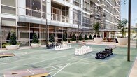 This dynamic outdoor amenity space is nestled within a contemporary urban high-rise development, offering a well-appointed courtyard environment designed for recreation and socializing. At its center lies a spacious multi-use game court finished in green modular sport surfacing, marked with shuffleboard lanes and accompanied by oversized chess sets and cornhole boards, providing a variety of engaging activities for residents or guests.

The courtyard is framed by the building's striking glass curtain wall façade, which floods the surrounding walkways with natural light and creates a seamless visual connection between interior and exterior spaces. Large, sculptural white planters filled with manicured topiaries and ornamental trees are thoughtfully arranged throughout, introducing lush greenery that softens the urban environment and adds a refined aesthetic.

String lights are strung overhead across the courtyard, lending a warm, inviting ambiance during evening hours. A pergola-covered terrace runs along one side of the space, offering shaded seating with wicker furnishings and open views of the surrounding city skyline. Travertine-style pavers line the perimeter walkways, contributing to the elevated, polished character of the space.

Raised planter beds with mature trees and layered plantings further define zones within the amenity area, while the building's upper-floor balconies overlook the courtyard below, reinforcing the sense of community and connectivity throughout this well-designed outdoor retreat.
