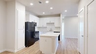 This single-story, 4-bedroom, 1-bathroom home offers a clean, modern aesthetic with a thoughtfully designed layout. The open-concept kitchen and living area serves as the heart of the home, featuring crisp white cabinetry, white quartz countertops, a central island, subway tile backsplash, and black appliances including a refrigerator, gas range, built-in microwave, and dishwasher. Recessed lighting illuminates the space, which flows seamlessly into the living area over light-toned wood-style flooring that continues throughout the home. The four bedrooms are bright and well-proportioned, with several rooms benefiting from natural light through slatted blinds. The primary bedroom offers direct access to the full bathroom and features a ceiling fan and ample wall space. One bedroom includes glass French doors that invite additional natural light. The shared full bathroom is finished with a white vanity, quartz countertop, undermount sink, and brushed nickel fixtures, complemented by a full shower-tub combination. A dedicated closet and hallway complete the floorplan. The home's consistent neutral palette, modern fixtures, and cohesive flooring create a bright, clean, and move-in-ready living environment.